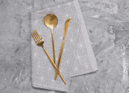 Beautiful cutlery set and kitchen towel on gray table, top viewの写真素材