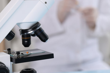 Quality control. Food inspector working in laboratory, focus on microscope
