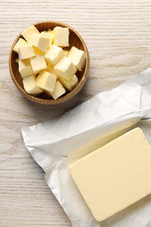 Tasty butter on light wooden table, flat layの写真素材