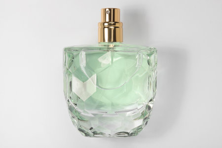 Luxury women's perfume in bottle on white background, top view