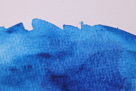 Abstract blue watercolor painting on white paper, top viewの写真素材