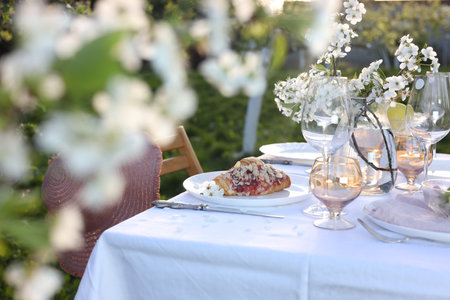 Stylish table setting with beautiful spring flowers in gardenの写真素材
