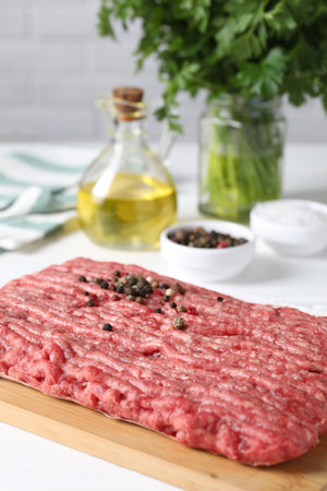 Raw ground meat, spices, oil and parsley on white tableの写真素材