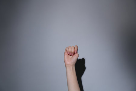SOS gesture. Woman showing signal for help on gray background, closeupの写真素材