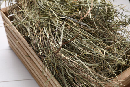 Crate with dried hay on white wooden table, closeupの写真素材