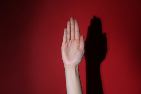 Woman showing open palm on red background, closeupの写真素材