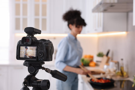 Food blogger cooking while recording video in kitchen, focus on cameraの写真素材