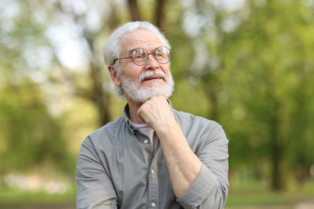 Portrait of happy grandpa with glasses in park