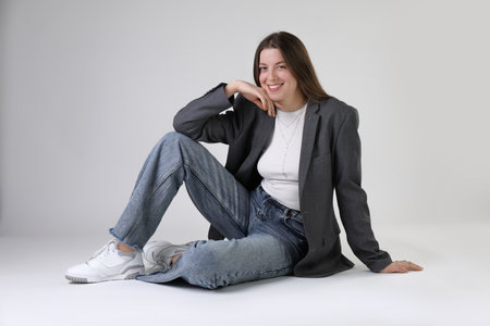 Portrait of beautiful young woman on light grey background
