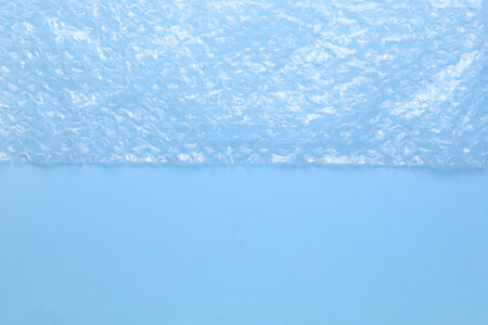 Transparent bubble plastic wrap on light blue background, top view. Space for textの写真素材