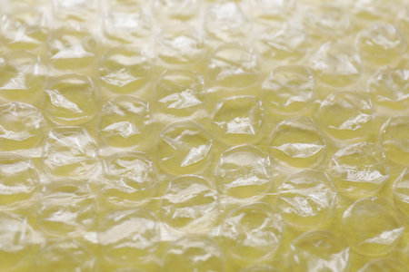 Transparent bubble plastic wrap on yellow background, closeupの写真素材