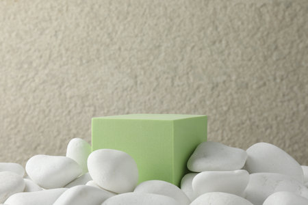 Presentation for product. Light green cube podium and white pebbles on blurred background. Space for textの写真素材