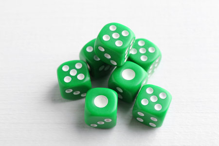 Many green game dices on white wooden table, above viewの写真素材