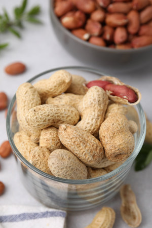 Fresh unpeeled peanuts on gray table, closeup