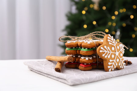 Decorated cookies on white table against blurred Christmas lights. Space for textの写真素材