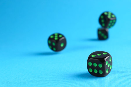 Many black game dices on light blue background