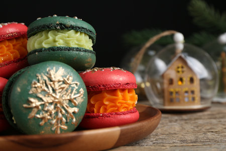 Beautifully decorated Christmas macarons and festive decor on wooden table, closeupの写真素材