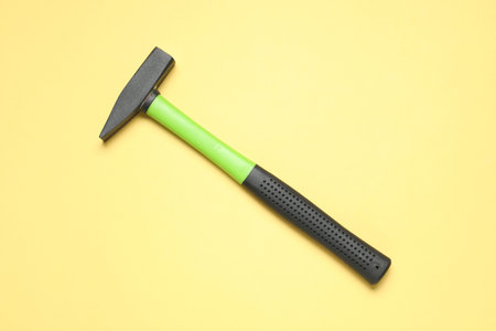 New hammer with rubber handle on yellow background, top viewの写真素材