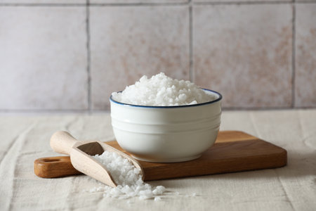 Organic salt in bowl and scoop on table