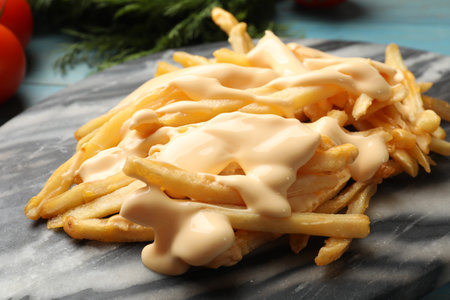 Delicious French fries with cheese sauce on table, closeupの写真素材