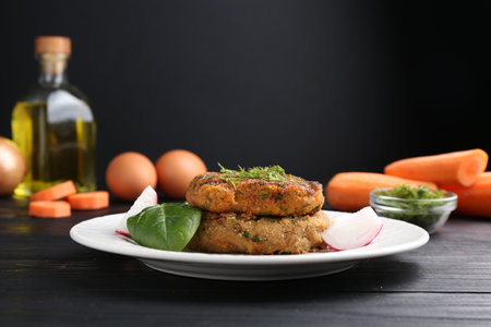 Vegetarian product. Tasty carrot cutlets served on black wooden tableの写真素材