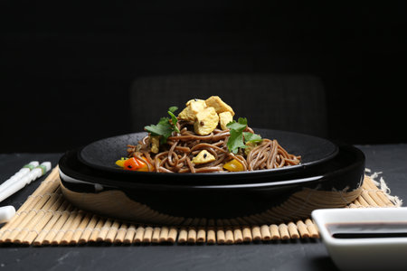 Stir-fry. Tasty noodles with meat and vegetables served on dark textured tableの写真素材