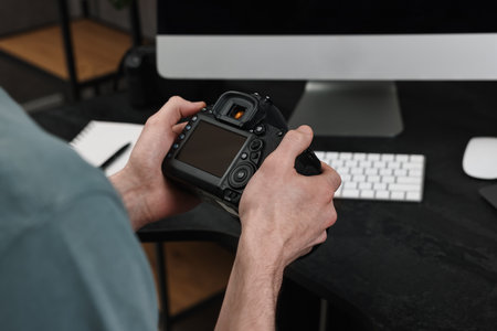 Photographer holding camera near dark table, closeupの写真素材