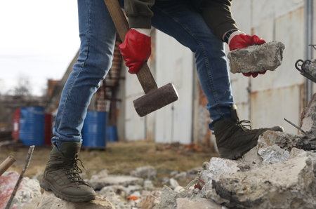 Man with sledgehammer and stone outdoors, closeupの写真素材