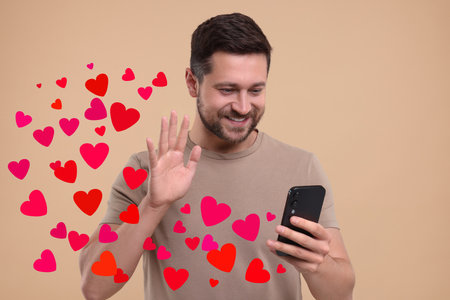 Long distance love. Man video chatting with sweetheart via smartphone on grey background. Hearts...