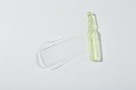 Skincare ampoule on white surface with gel, top viewの写真素材