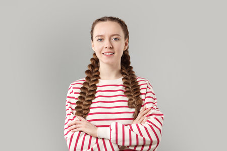 Woman with braided hair on grey background