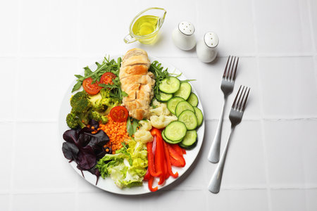 Balanced diet and healthy foods. Plate with different delicious products on white tiled table, flat layの写真素材