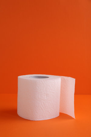 Soft toilet paper roll on orange background. Space for textの写真素材