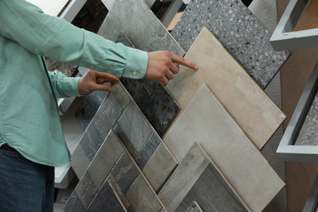 Man choosing tile among different samples in store, closeupの写真素材