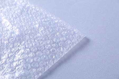 Transparent bubble plastic wrap on gray background, closeup. Space for text