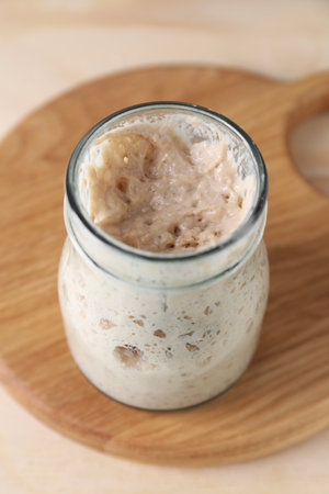 Sourdough starter in glass jar on table, closeupの写真素材