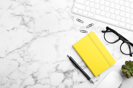 Flat lay composition with different office stationery on white marble table, space for textの写真素材