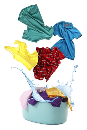 Clothes in air over laundry basket on white backgroundの写真素材