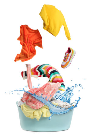 Clothes in air over laundry basket on white backgroundの写真素材