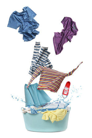 Clothes in air over laundry basket on white backgroundの写真素材