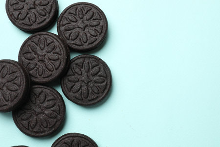 Tasty sweet sandwich cookies on light blue background, flat lay. Space for textの写真素材