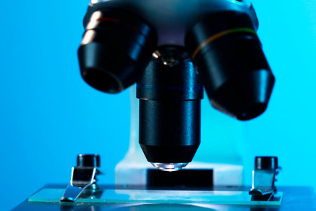 Microscope with glass slide on blue background, closeupの写真素材