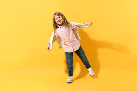 Fashion concept. Stylish girl posing on yellow backgroundの写真素材