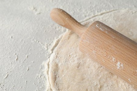 Raw dough and rolling pin on table, space for textの写真素材