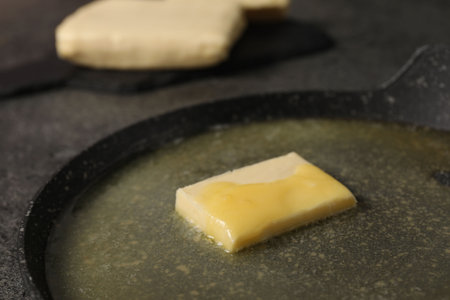 Melting butter in frying pan on gray table, closeupの写真素材