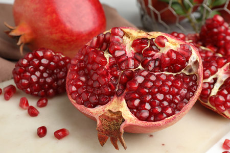 Piece of fresh pomegranate and seeds on white table, closeupの写真素材