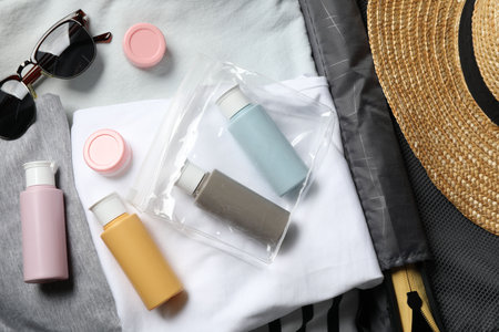 Cosmetic travel kit, plastic bag and accessories in suitcase, top viewの写真素材