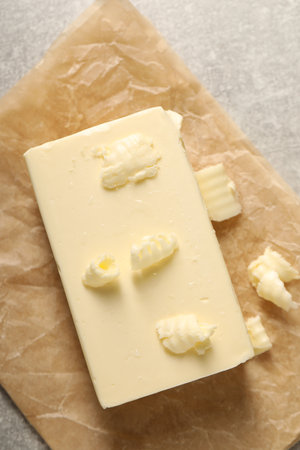 Tasty butter on gray table, top view