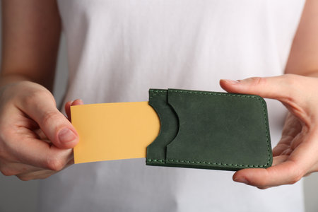 Woman holding leather business card holder with card, closeup