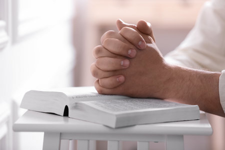 Religion. Christian man praying over Bible indoors, closeupの写真素材